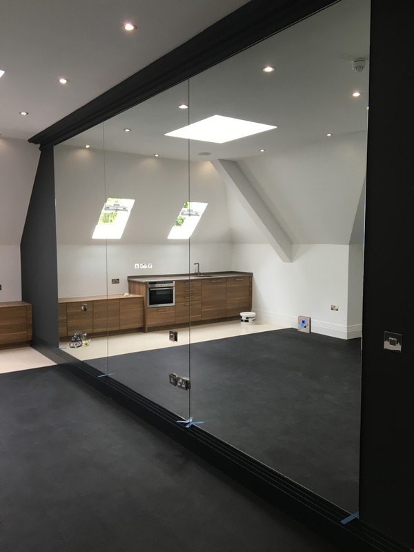 Frameless glass partition in loft conversion by Northolt glaziers