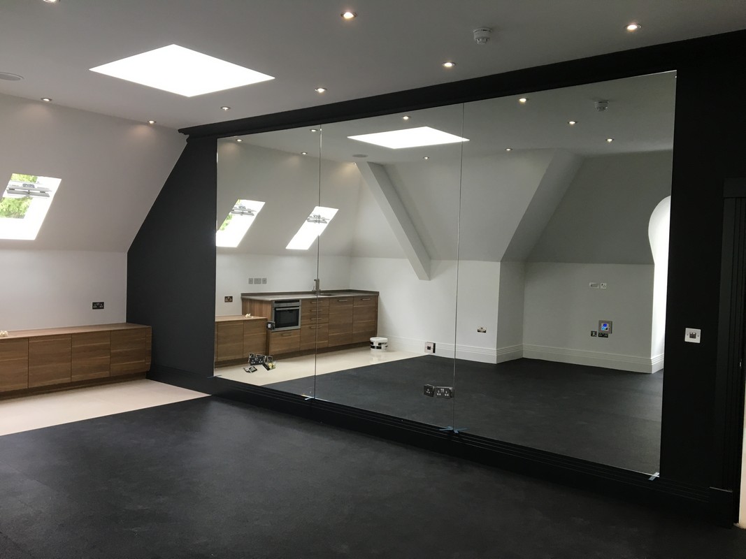 Frameless glass wall dividing loft conversion in Northolt